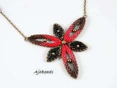 a red and black beaded flower on a gold chain