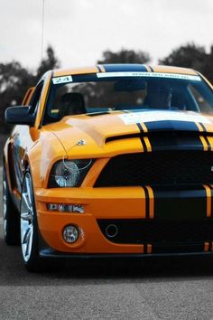 an orange mustang with black stripes on it