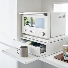 a coffee cup is sitting in front of a microwave