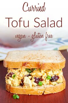 a close up of a sandwich on a table with the words, currie tofu salad vegan gluten free