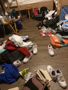 a pile of luggage sitting on top of a hard wood floor next to a bed