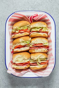 a bunch of sandwiches in a blue and white container on top of a gray table