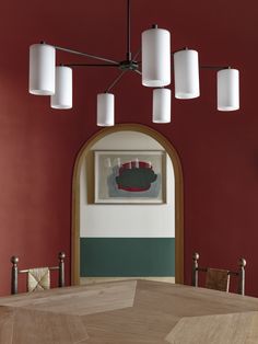 a chandelier hanging from the ceiling in a room with red walls and green accents