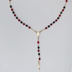 The perfect gift for any occasion Can be used as a statement of faith or as a fashionable piece of jewelry Elegant crystals Encourages praying the rosary This gold-plated rosary necklace features a stunning Miraculous Medal with a chain lined with crystals (red and black). The traditional rosary design, adds meaning to this delicate piece of jewelry, while the crystal beads lend a feminine touch. The necklace serves as a reminder to include prayer in our everyday lives, as well as adding a color Gold Rosary With Gemstone Beads Gift, Crucifix Jewelry With Faceted Beads For Gift, Crucifix Shaped Jewelry With Faceted Beads As Gift, Crucifix Jewelry With Faceted Beads As Gift, Elegant Beaded Chain Rosary For Gift, Elegant Beaded Chain Rosary As Gift, Faceted Beads Crucifix Rosary As Gift, Elegant Rosary With Polished Beads For Gift, Elegant Rosary With Polished Beads As Gift