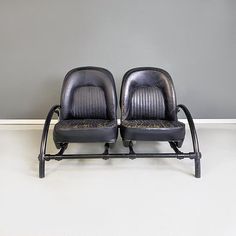 two black leather chairs sitting next to each other