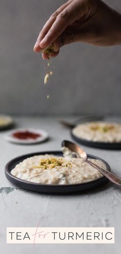 a person is sprinkling some food on top of plates