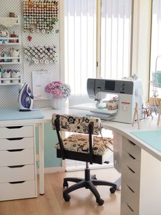 a sewing machine sitting on top of a table next to a desk with a chair