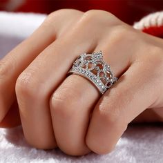 Delicate and romantic, this crown-shaped ring will utterly delight the queen of your heart. Fashioned in sleek sterling silver, this ring features open hearts and sparkling stones. Twinkling round stones, meaningful hearts and milgrain detailing complete this lovely style. A regal choice for your princess, this ring creates a romantic look. Carat Weight: 0.762 ctStone Size: 1.1,1.25,1.5 mmStone Type: Jeulia® StoneNumber of Stones: 31 Stone Color: Diamond WhiteStone Shape: RoundWeight: 5.63 gWidt Queen Crown Ring Design, Crown Ring Queen, Luxury Crown Design Cubic Zirconia Rings, Elegant Crown Design Cubic Zirconia Rings, Luxury Cubic Zirconia Rings With Crown Design, Elegant Cubic Zirconia Rings With Crown Design, Elegant Crown-shaped Cubic Zirconia Rings, Cubic Zirconia Crown Design Rings, Cubic Zirconia Diamond Ring With Crown Design