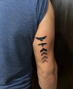 a person with a tattoo on their arm that has three arrows in the shape of an arrow