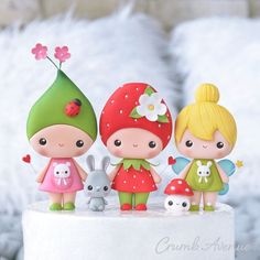 three small figurines on top of a cake