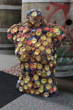 a sculpture made out of beer caps sitting on top of a rug