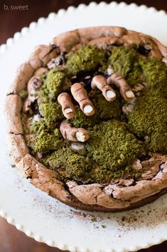 there is a chocolate cookie with green toppings in the shape of hands on top