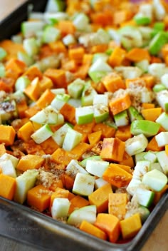 a pan filled with chopped vegetables on top of a wooden table