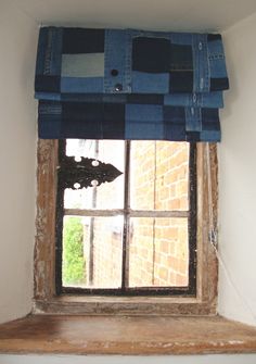 an open window with a blue checkered curtain