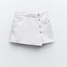 Five Pocket Skort With A High Waist. Washed Effect. Ripped Trim Detail. Front Hidden Zip And Button Closure. White White High-rise Jeans With Buttons, White High Rise Jeans With Buttons, Mid-rise Button Jean Shorts For Spring, Mid-rise Shorts With Button Zip Fly For Spring, Spring Cotton Shorts With Button Zip Fly, White Buttoned Shorts For Spring, Cotton Jean Shorts With Buttons For Spring, Spring Cutoff Jean Shorts With Buttons, Spring Cotton Jean Shorts With Buttons