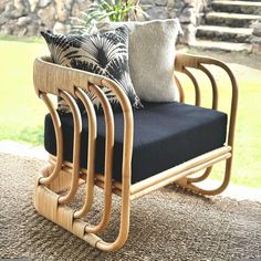 a chair with two pillows on it sitting in front of a stone wall and stairs