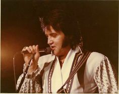 elvis presley singing into a microphone on stage