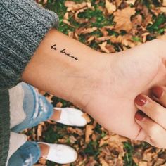 a person's arm with a small tattoo that says love on the left wrist