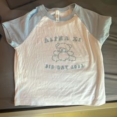 a white shirt with a teddy bear on the front that says, alpha xi did day 2013