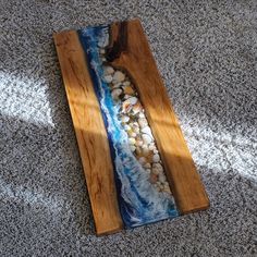 a wooden tray with shells in it on the floor