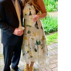 a man and woman standing next to each other in front of some flowers on the ground