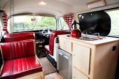 the interior of an old camper with red leather seats and wood trimmings