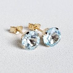 Glistening blue sparkles radiate throughout these sky-blue topaz studs. An affordable alternative to aquamarine. These earrings are available in your choice of a 14K gold-filled setting, 14k solid gold setting (yellow or white), or .925 solid silver setting. Both gold metals are tarnish-resistant, water-resistant, and hypoallergenic. These unique and trending stones are 6mm, making is roughly half a carat each. Whether you need a pair of earrings for everyday use or a special occasion, these classic studs won't disappoint. Please see the black-and-white picture for size reference. Keep in mind, this is for reference only. Ear sizes differ from person to person.  What is the difference between 14k gold-filled and 14k solid gold? 14k solid gold is 100% gold all the way through. 14k gold-fill Blue Topaz Birthstone Earrings For Anniversary, Anniversary Blue Topaz Birthstone Earrings, Light Blue Jewelry With Prong Setting For A Gift, Yellow Gold Blue Topaz Earrings For Gift, Classic Blue Topaz Birthstone Earrings, Gift Blue Topaz Birthstone Earrings, Light Blue Gemstone Earrings For Anniversary, Aquamarine Color, Aquamarine Colour