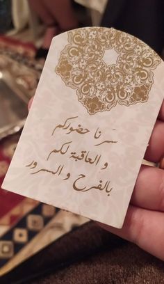 a person holding up a card with arabic writing on it in front of other cards