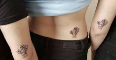 two women with tattoos on their stomachs, one has cactus and the other has flowers