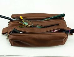 "The 2Rec pencil case in chocolate brown soft Italian cowhide. It is lined with cotton fabric in either floral or plain grey. This case was made to carry around your purse. It has two zippered compartments for your pens or makeup and a smaller one in the middle. It can easily fit more than 3 dozens of pens Customize it in fabric or leather in your favorite color combination and why not mix and match it with one of the other bags in my shop http://etsy.me/1haNFVO Inside the bag, the lining is mad Brown Classic Bag With Pen Slots, Classic Brown Bags With Pen Slots, Brown Pouch Pencil Case For Travel, Brown Travel Pouch Pencil Case, Travel Brown Pouch Pencil Case, Brown Pouch Pencil Case For Daily Use, Brown Pencil Case With Zipper For Daily Use, Brown Rectangular Pencil Case For Everyday Use, Brown Rectangular Pencil Case For Daily Use