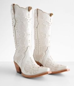 a pair of white cowboy boots sitting on top of a table