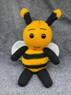 a small knitted bee sitting on top of a gray blanket