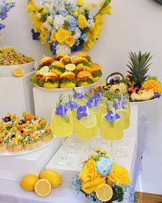 a table topped with lots of different types of food and glasses filled with drinks next to each other