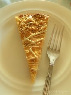 a piece of pie sitting on top of a white plate next to a knife and fork