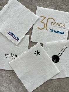 four napkins with logos on them sitting next to each other