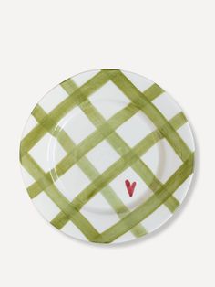 a green and white checkered plate with a red heart on the center, against a white background