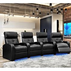 a living room with black leather recliners in front of a flat screen tv