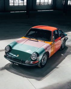 an orange, green and blue car parked in a garage