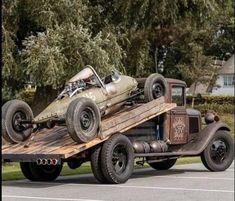 an old pick up truck is being towed down the street