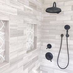 a bathroom with white tile and black shower faucet