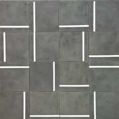 a tile floor with white lines on the top and bottom in grey color, as well as squares