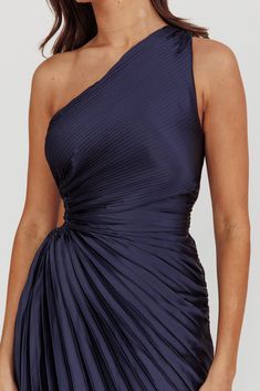 a woman wearing a one shoulder dress