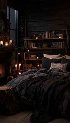 a dark bedroom with lit candles and bookshelves on the wall, along with a large bed covered in black linens