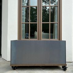 a couch sitting on top of a metal cart in front of a white building with large windows