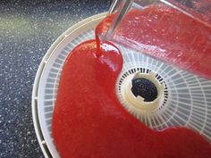 a red liquid is being poured into a blender