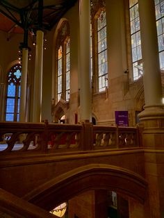 the interior of a large church with stained glass windows and columns on either side of it