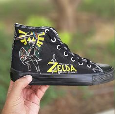 "😍 FREE SHIPPING 😍 Looking for a unique gift for your game-loving partner? Look no further than our Legend of Zelda custom shoes! These black high-top Converse sneakers are hand-painted with iconic imagery from the beloved video game series. Whether they're a fan of Link, Zelda, or the entire kingdom of Hyrule, these shoes are sure to be a hit. Perfect for adults and plus sizes, our custom shoes make a great boyfriend gift or a treat for yourself. Each pair is made to order, so you can be sure Sporty Low-top Sneakers Gift, Custom Logo Sneakers With Round Toe For Streetwear, Streetwear Custom Sneakers With Round Toe And Logo, Customizable High-top Sneakers As A Gift, Customizable High-top Sneakers As Gift, Black Casual Sneakers With Custom Artwork, Casual Customized Black Sneakers, Casual Black Customized Sneakers, Customizable Low-top Sneakers As Gift