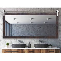 a bathroom with two sinks and a large mirror over it's counter top that has lights on above the sink