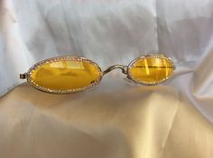 Swarovski crystal embellished, yellow lense, gold frame, vintage oval shape, unique womens sunglasses.  Add glamour & bling to your ensemble, ensuring you are the most stylish, every day at every event.  These sunglasses are a conversation piece that will get you noticed.  I hand embellish my couture creations with materials sourced from the garment district in NYC, as well as gem & mineral shows across the country. A stunning gift for a fashionista. I happily offer custom colors and strengths. In addition to many Swarovski crystal colors, I also have a variety of semi precious stones such as turquoise, tiger eye, peridot, amethyst, blue topaz, green jasper, aventurine, garnet, faux pearls & vintage beads.  I also offer matching sets for bridal parties or other groups. Please message me fo Crystal Colors, Green Jasper, Bridal Parties, Womens Sunglasses, Vintage Beads, Sunglasses Vintage, Conversation Piece, Gold Frame, Tiger Eye