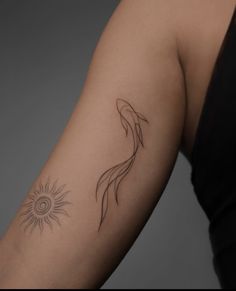 a woman's arm with a tattoo on it that has a fish and sun